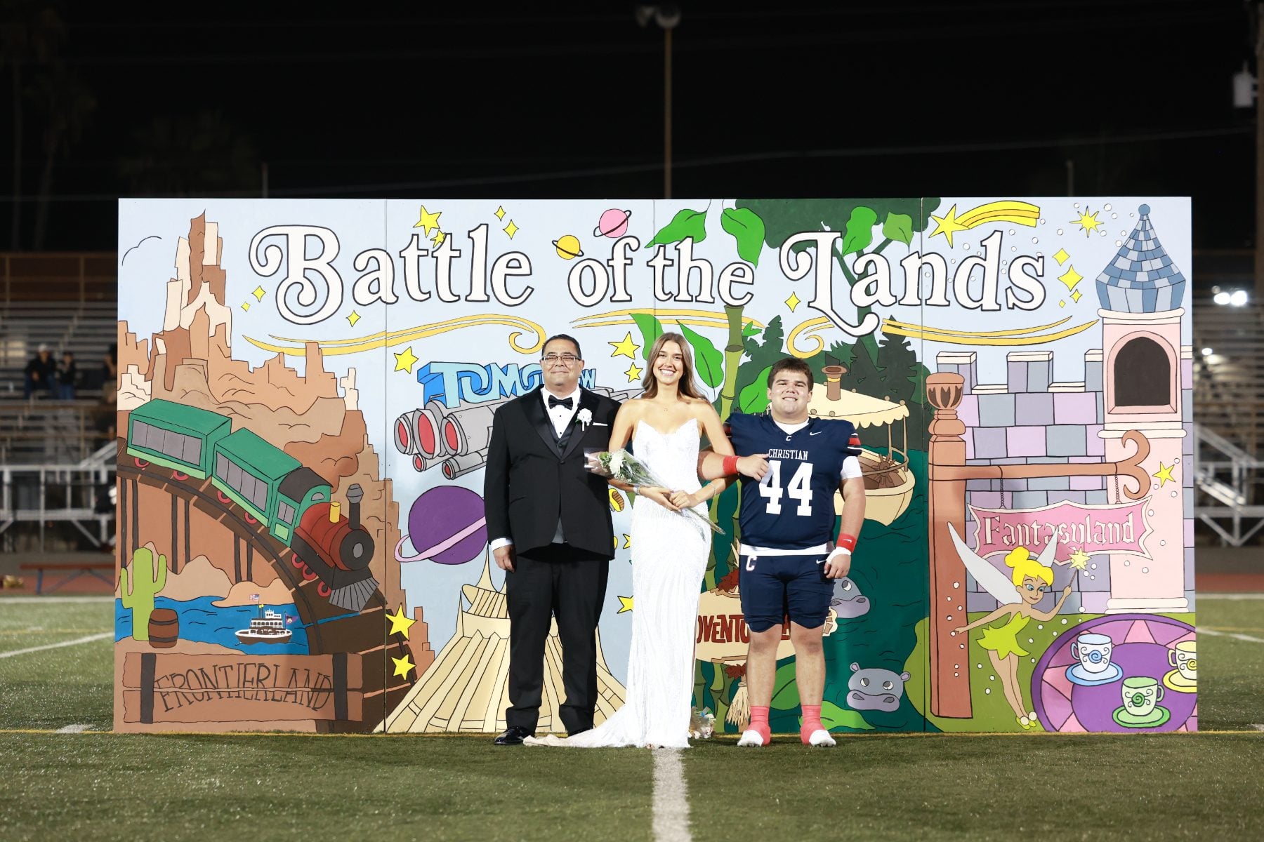 Homecoming court members pose with football player wearing number 44