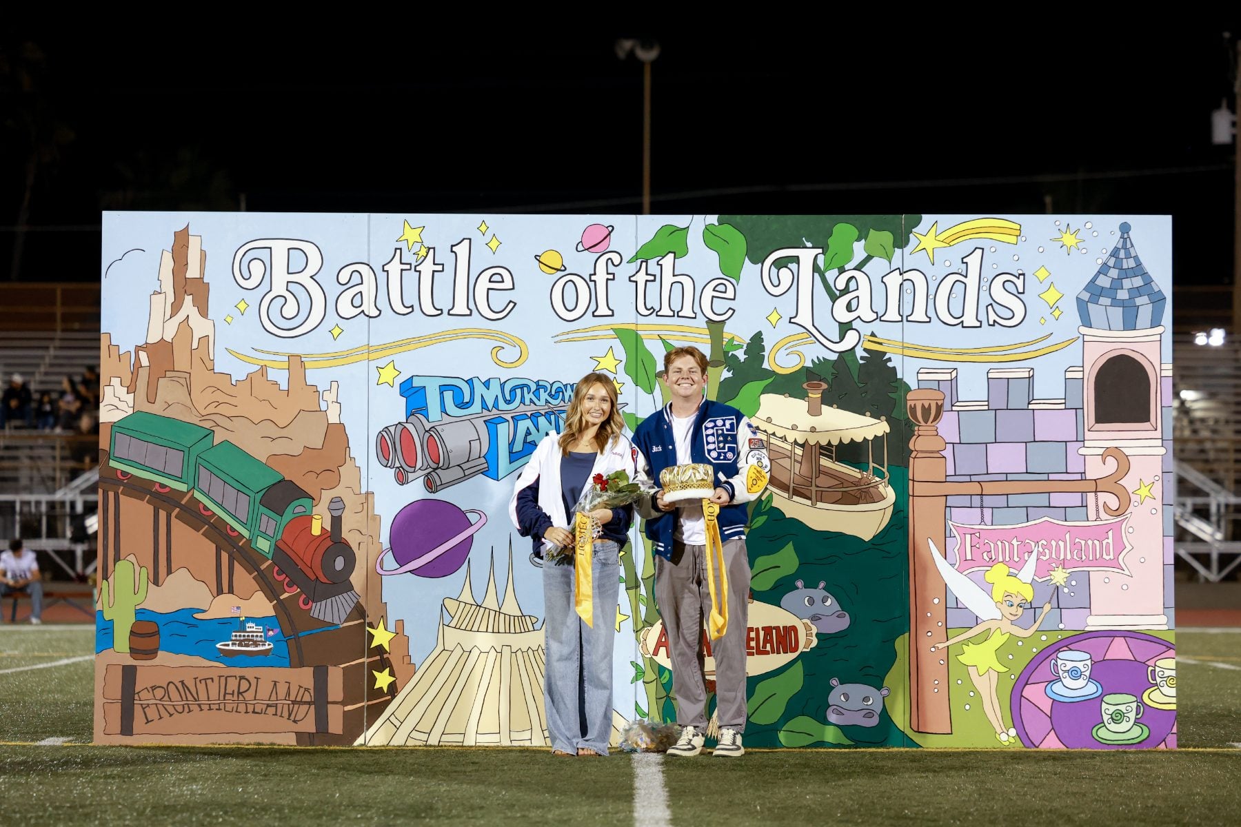 Homecoming king and queen pose at Battle of the Lands backdrop