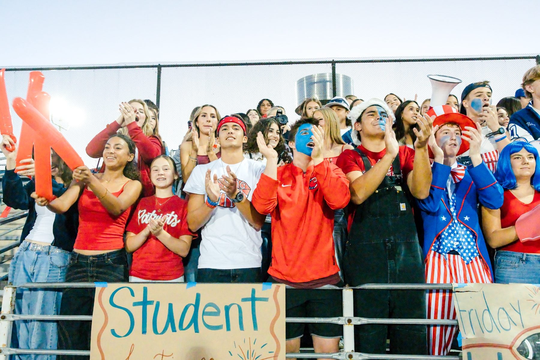 Students cheer in the stands holding a Student sign at homecoming
