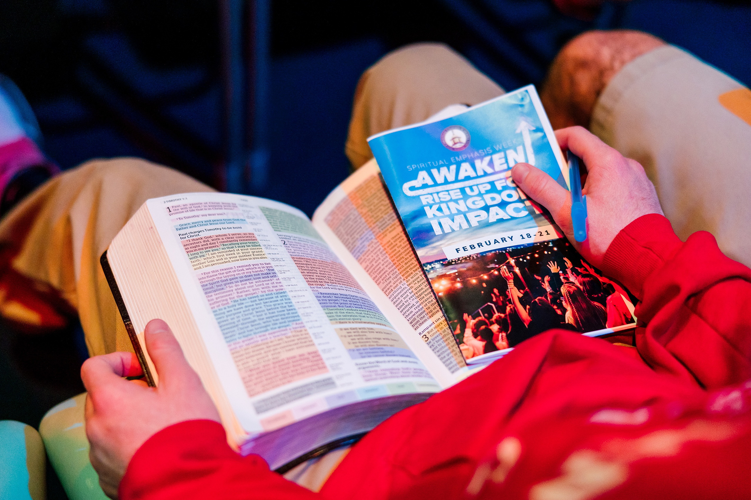 Spiritual Emphasis Week 2025 — 08 Students take notes during chapel presentation with blue stage lighting