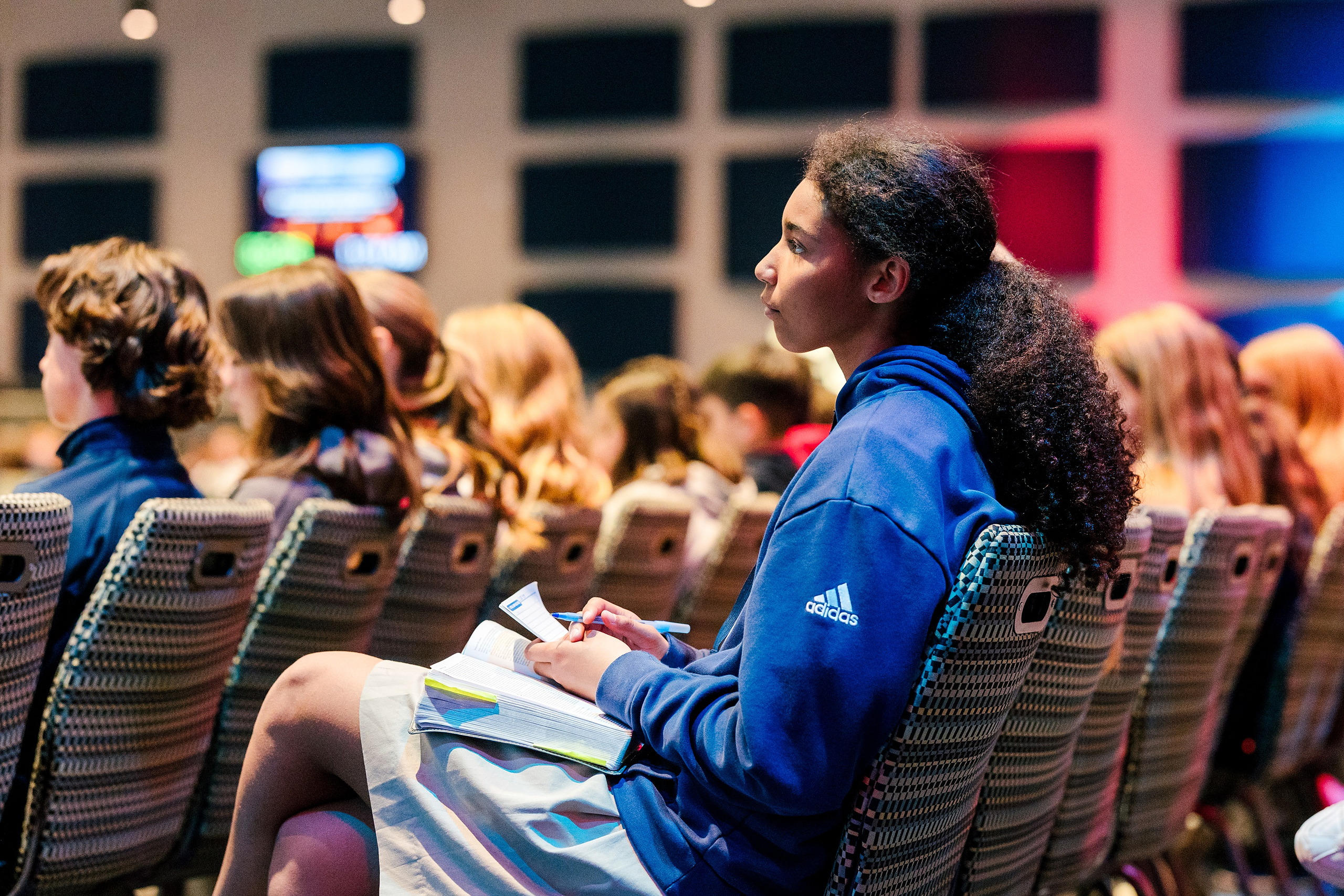 Spiritual Emphasis Week 2025 — 09 Close-up of student hands writing notes on paper during chapel service