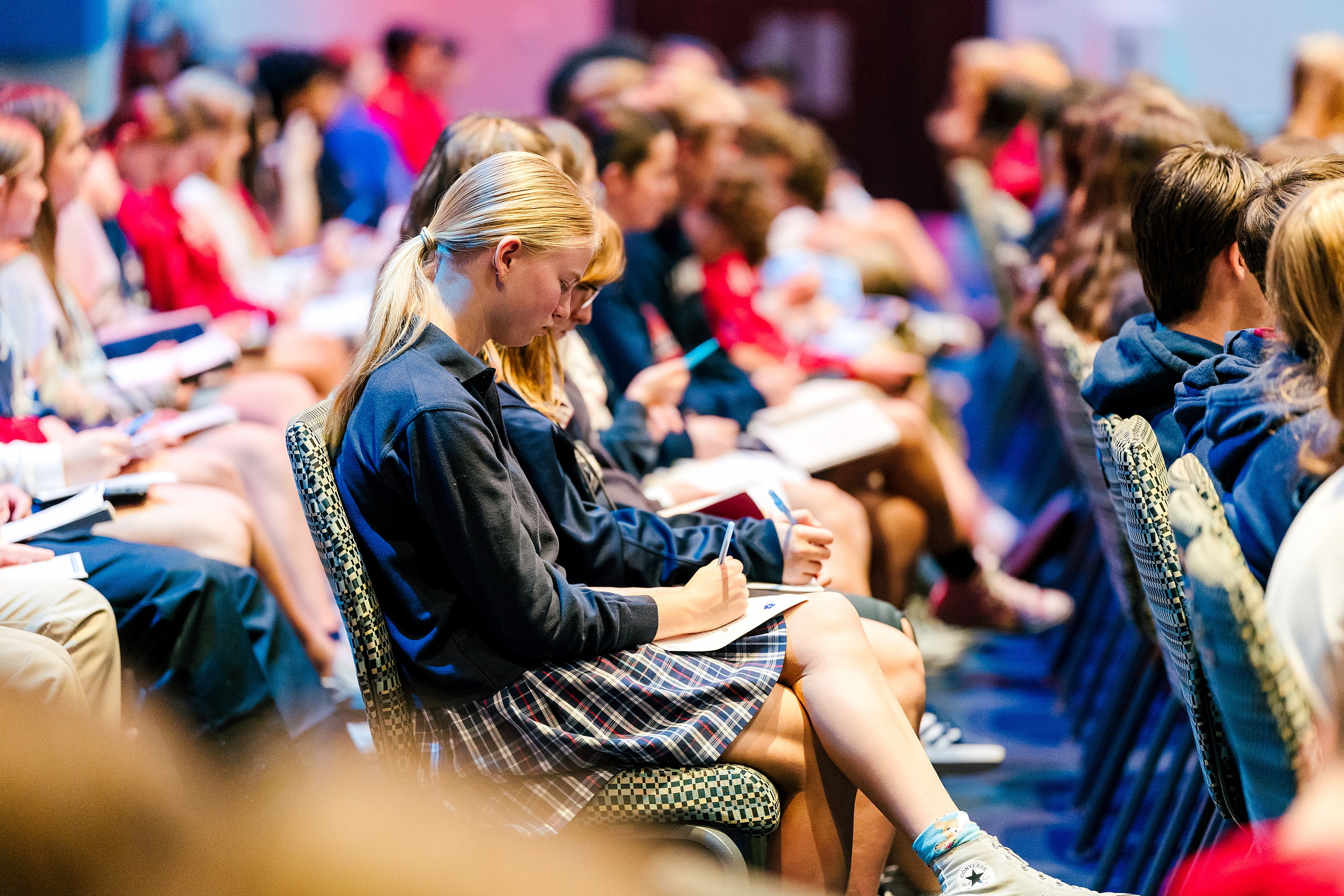 Spiritual Emphasis Week 2025 — 13 Female student in blue jacket takes notes while seated in chapel