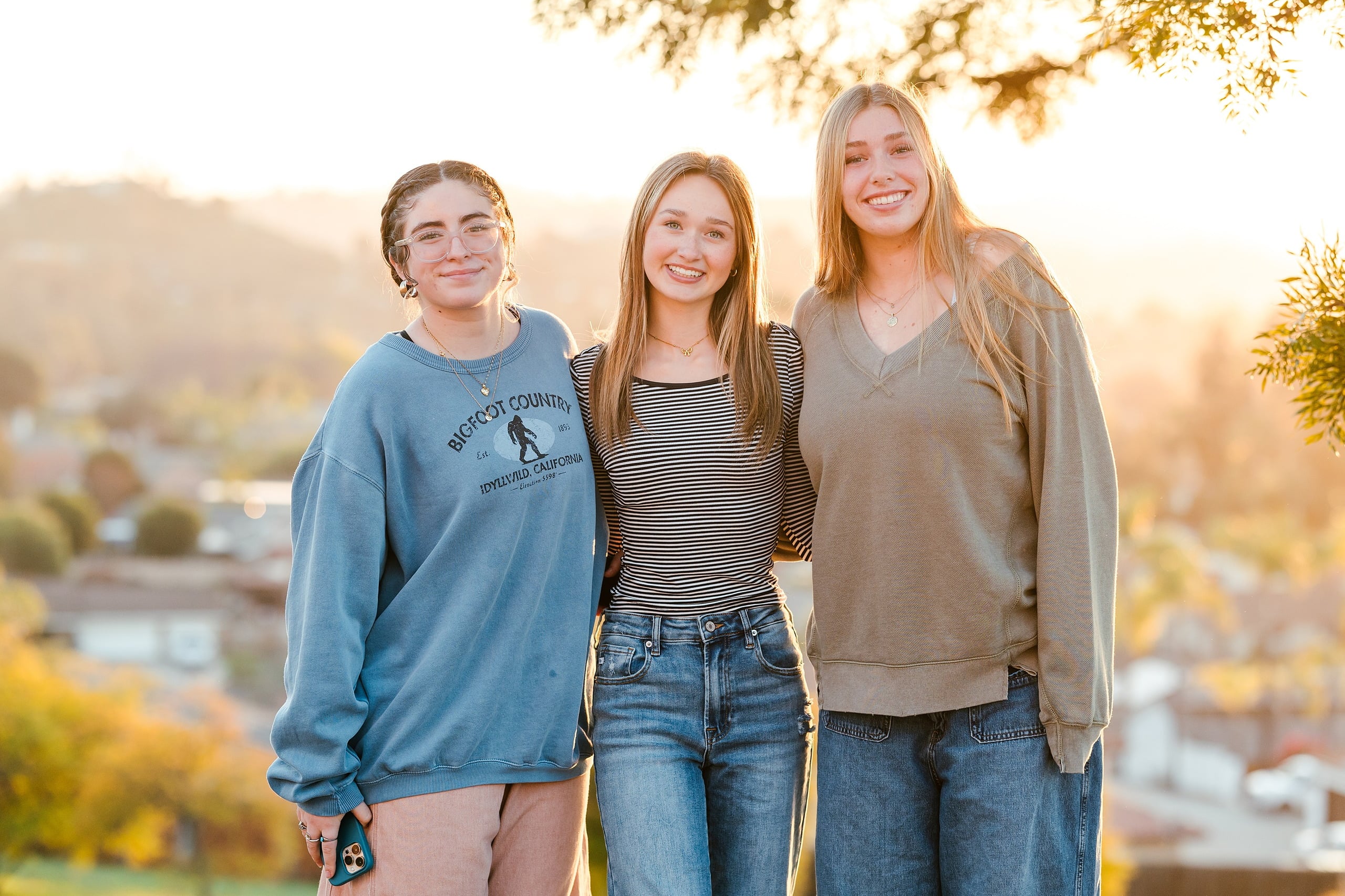 Spiritual Emphasis Week 2025 — 21 Three female students pose together outdoors during golden hour