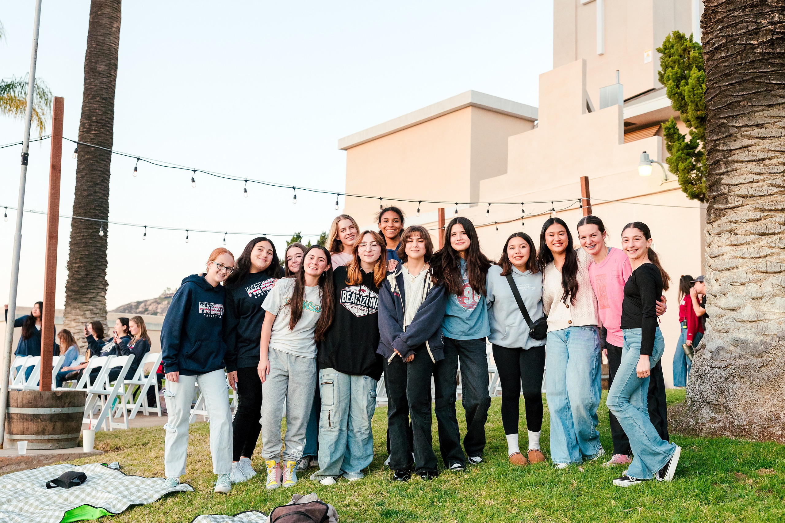Spiritual Emphasis Week 2025 — 28 Three teen girls pose together at golden hour with city view