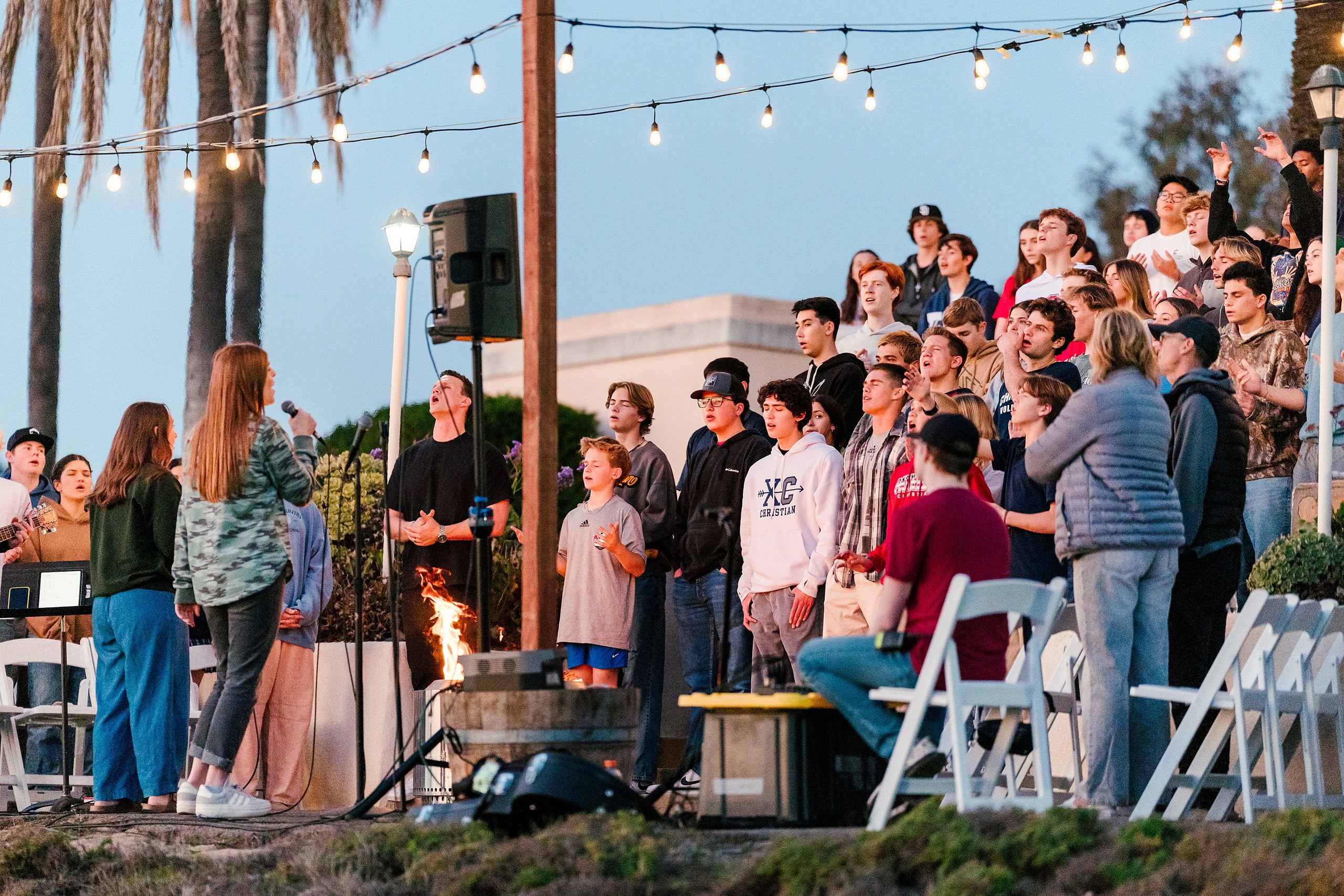 Spiritual Emphasis Week 2025 — 36 Students gather under string lights during indoor evening worship session