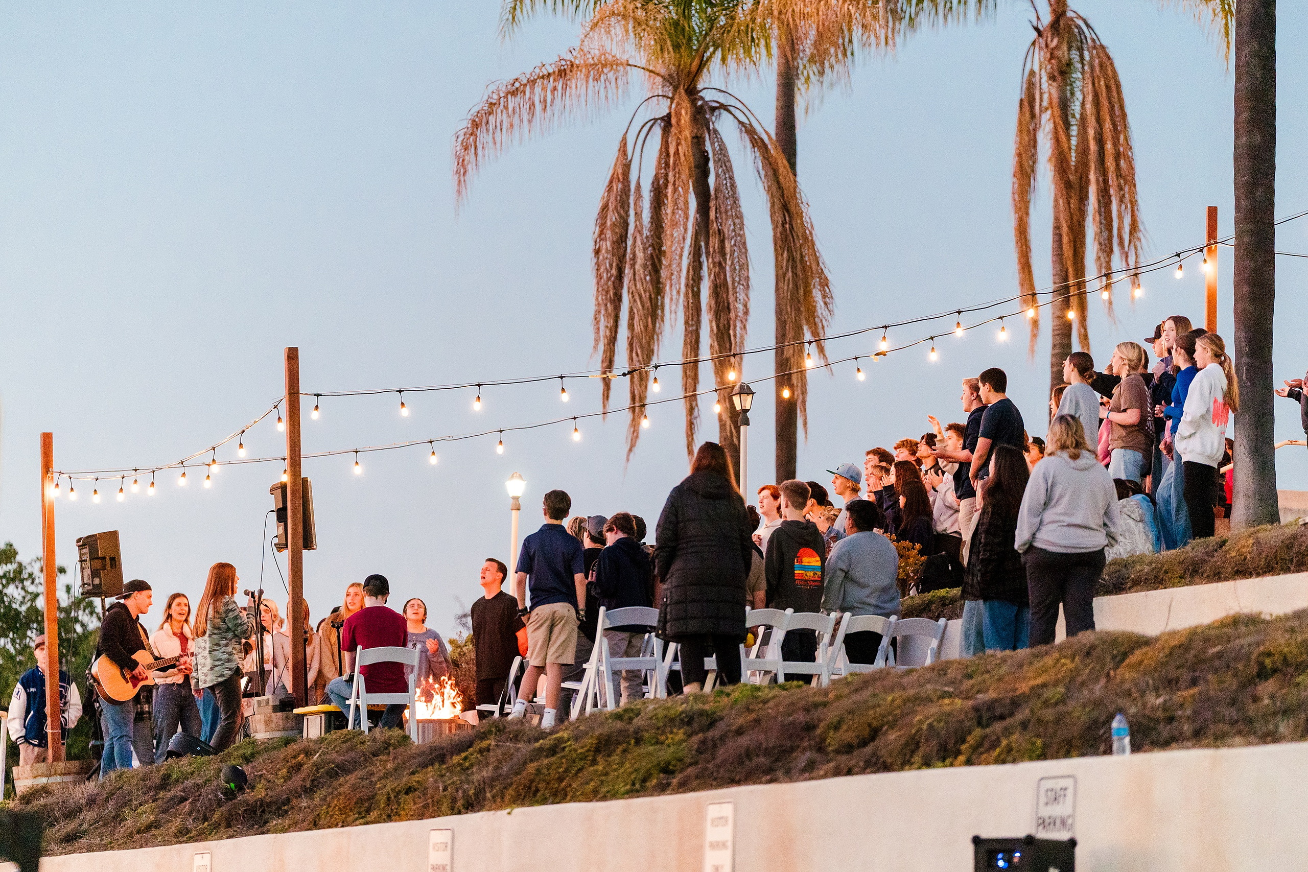 Spiritual Emphasis Week 2025 — 37 Students stand together under string lights at outdoor event at dusk