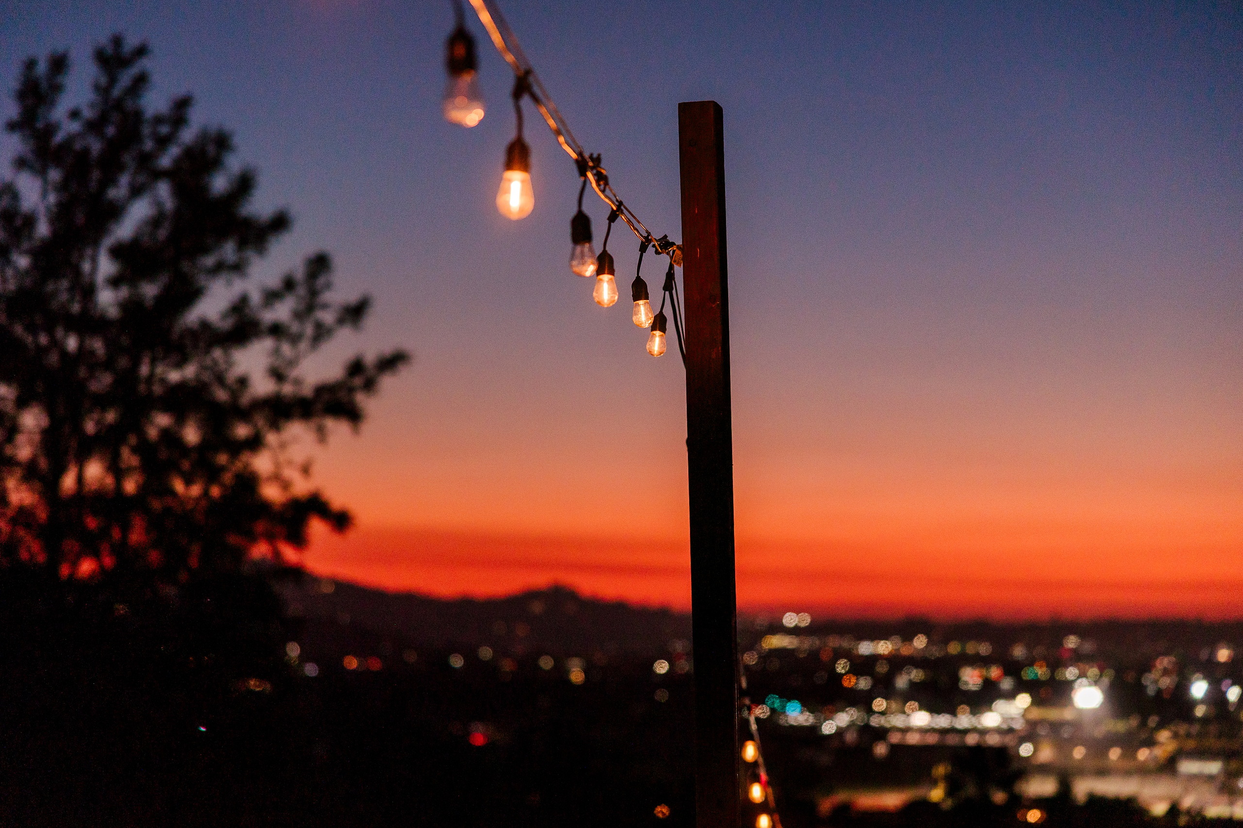 Spiritual Emphasis Week 2025 — 43 Warm string lights and sunset glow over distant city at evening worship