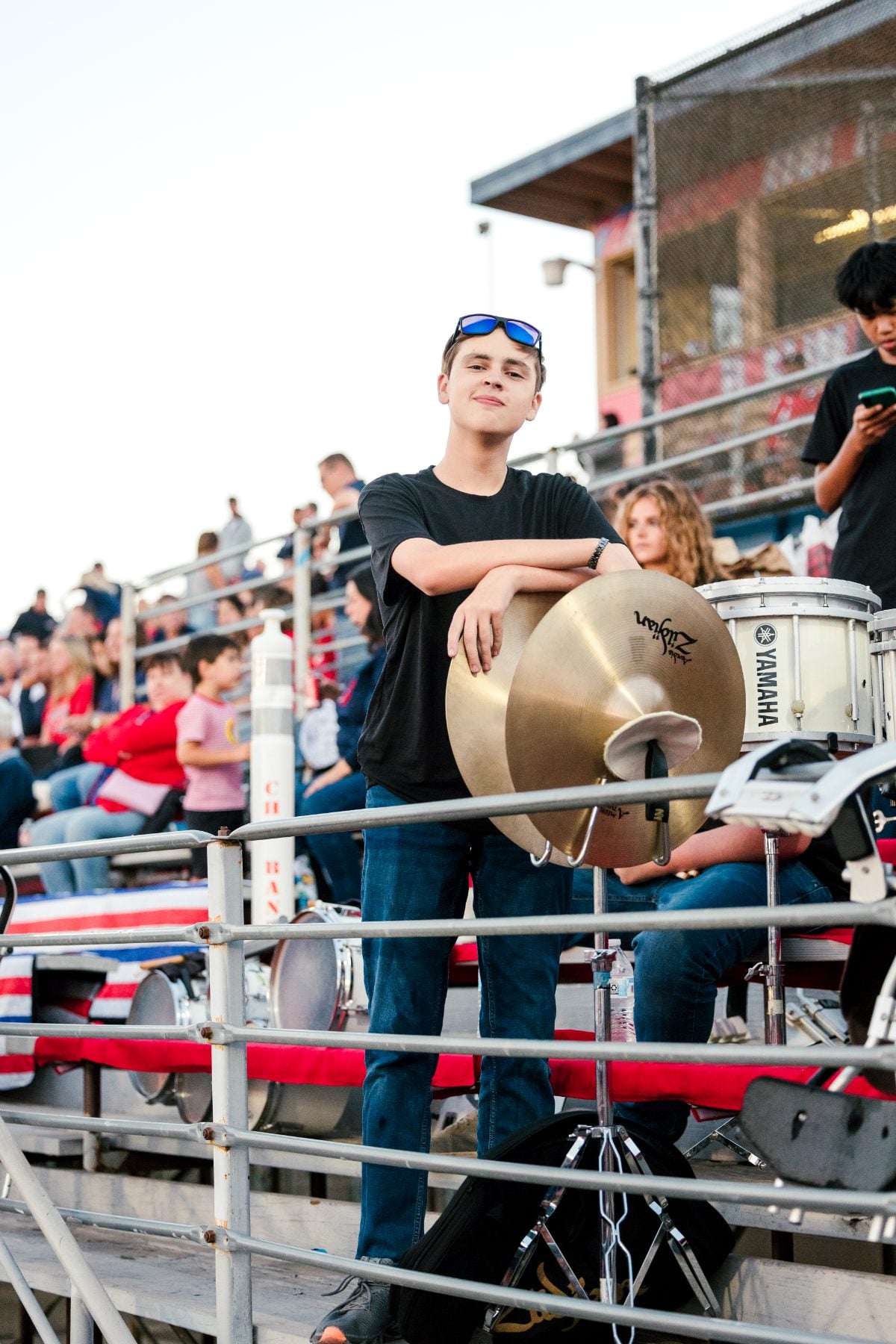 A student holds cymbals in the band section during the game