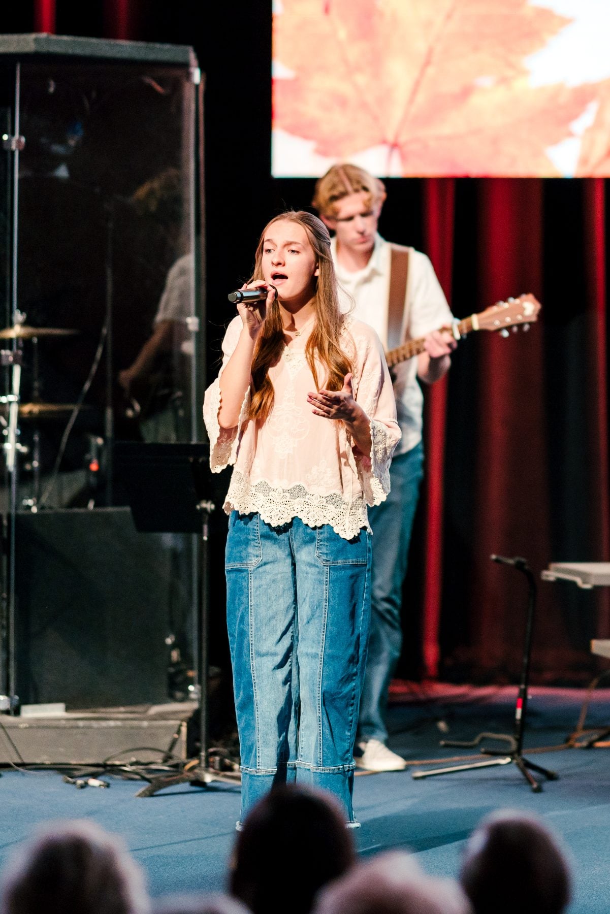 A student sings with a guitarist behind her during the Fall Choral Concert