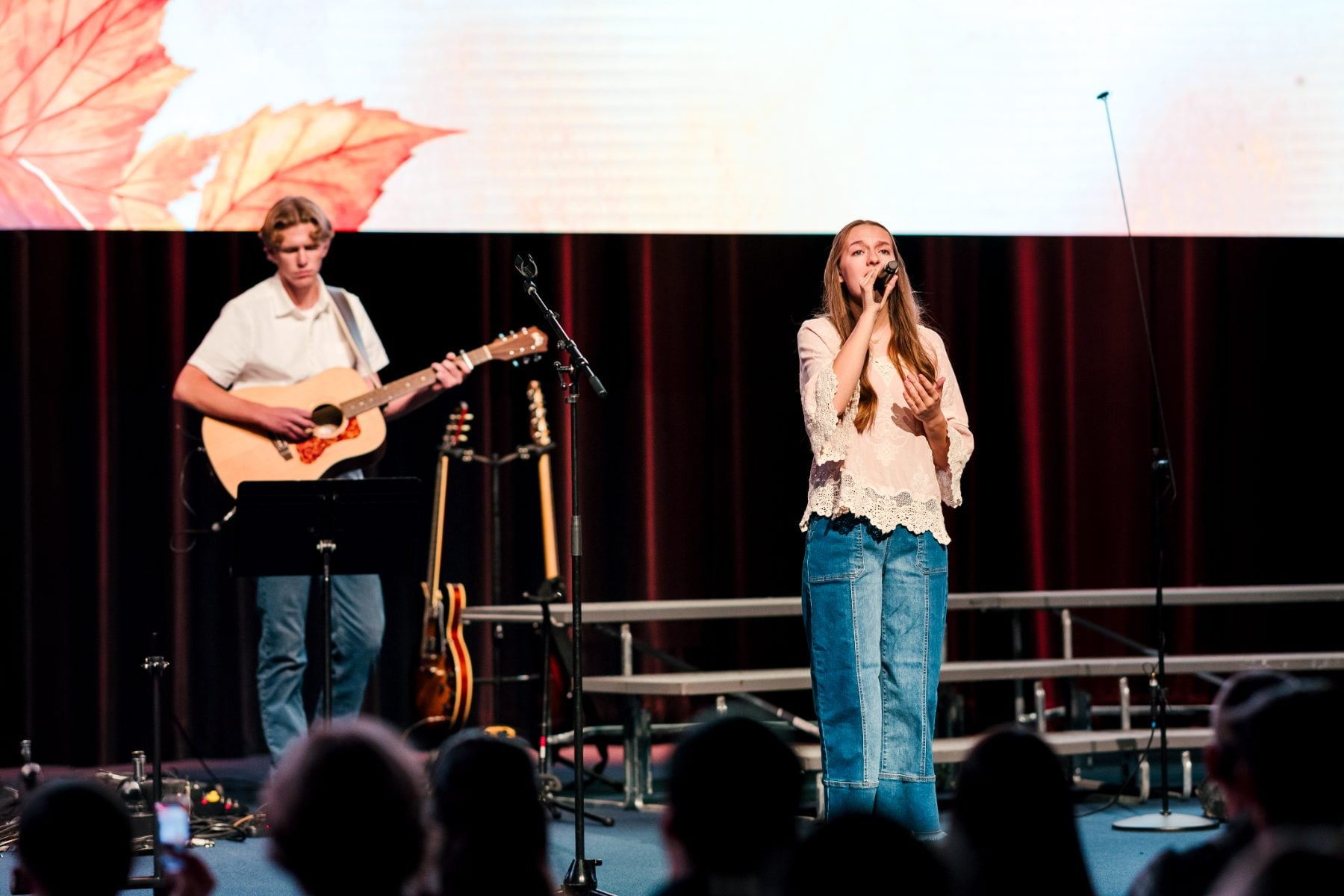 A student singer performs duet with guitarist at Fall Choral Concert