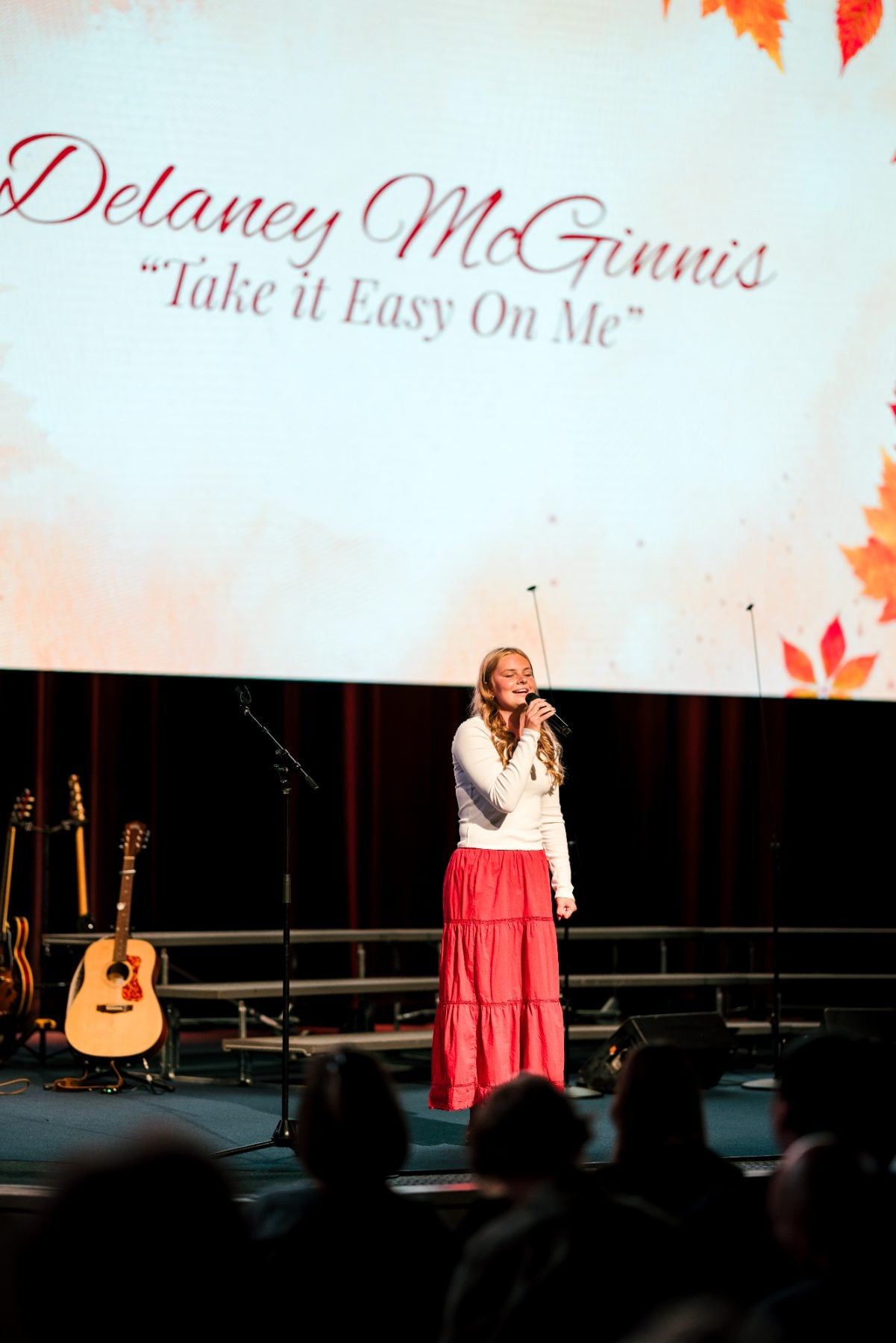A student performs a solo song beneath an autumn leaf slide, Event Center
